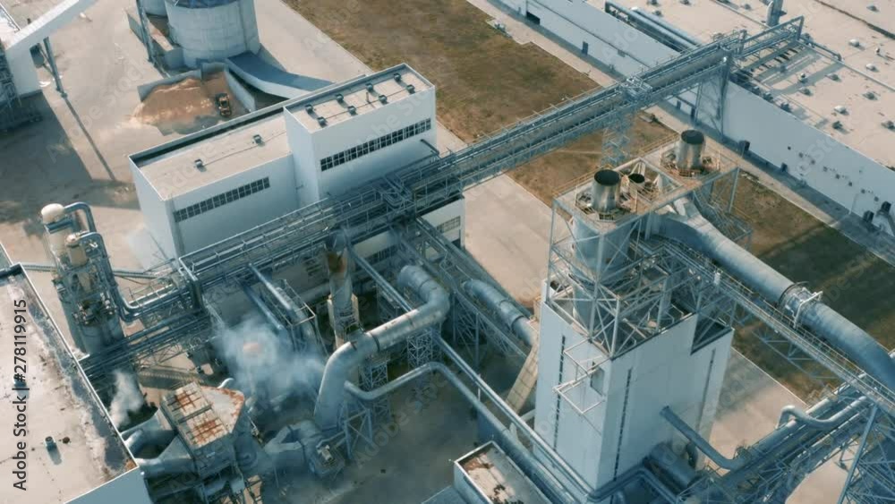 Aerial view of a modern plant (factory) with pipeline and smoking chimney Aerial view of a modern plant (factory) with pipeline and smoking chimney
