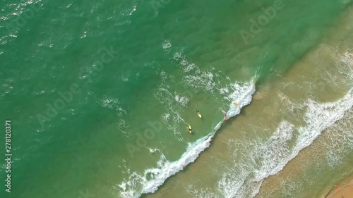 Circling over the sea and surfers