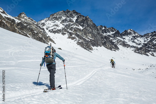 Two skiers skinning up slope near Snowbird Mine in Hatcher Pass area in the Talkeetna Mountains, Alaska.
