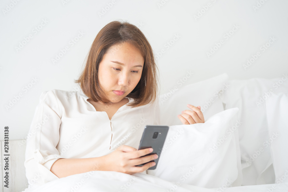 Beautiful Asian girl sleeping on a smartphone. Play on the media. Talk to a friend or comments in the Internet communication by mobile phone. Work through phone Working outside the office Beautiful Asian girl sleeping on a smartphone. Play on the media. Talk to a friend or comments in the Internet communication by mobile phone. Work through phone Working outside the office