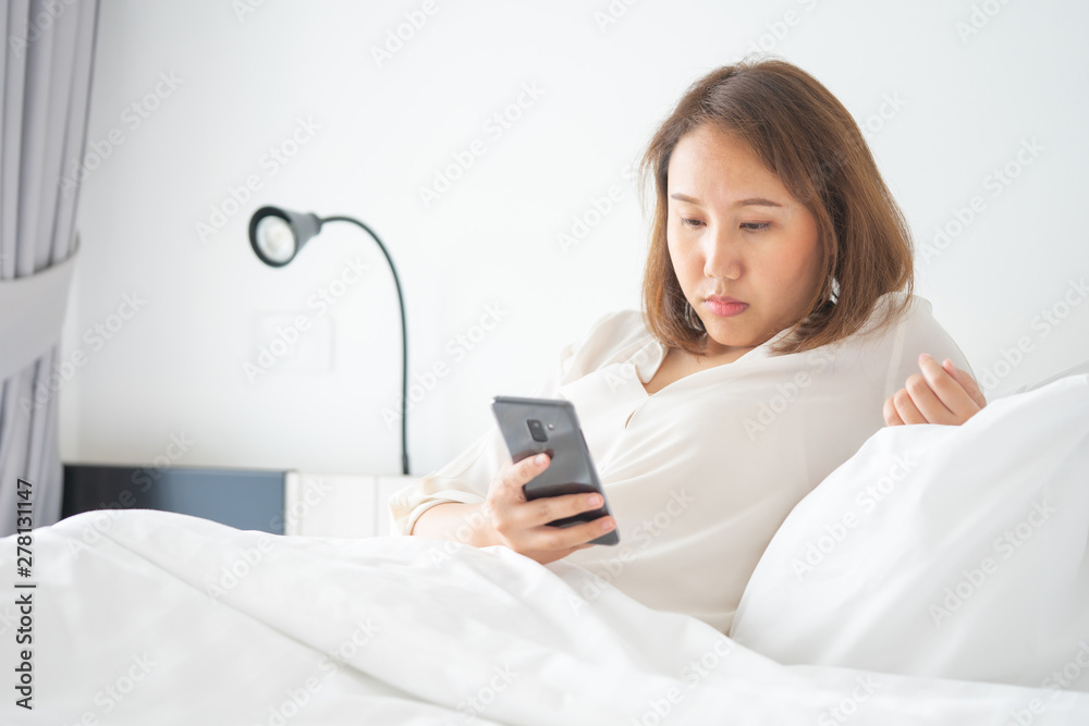 Beautiful Asian girl sleeping on a smartphone. Play on the media. Talk to a friend or comments in the Internet communication by mobile phone. Work through phone Working outside the office Beautiful Asian girl sleeping on a smartphone. Play on the media. Talk to a friend or comments in the Internet communication by mobile phone. Work through phone Working outside the office