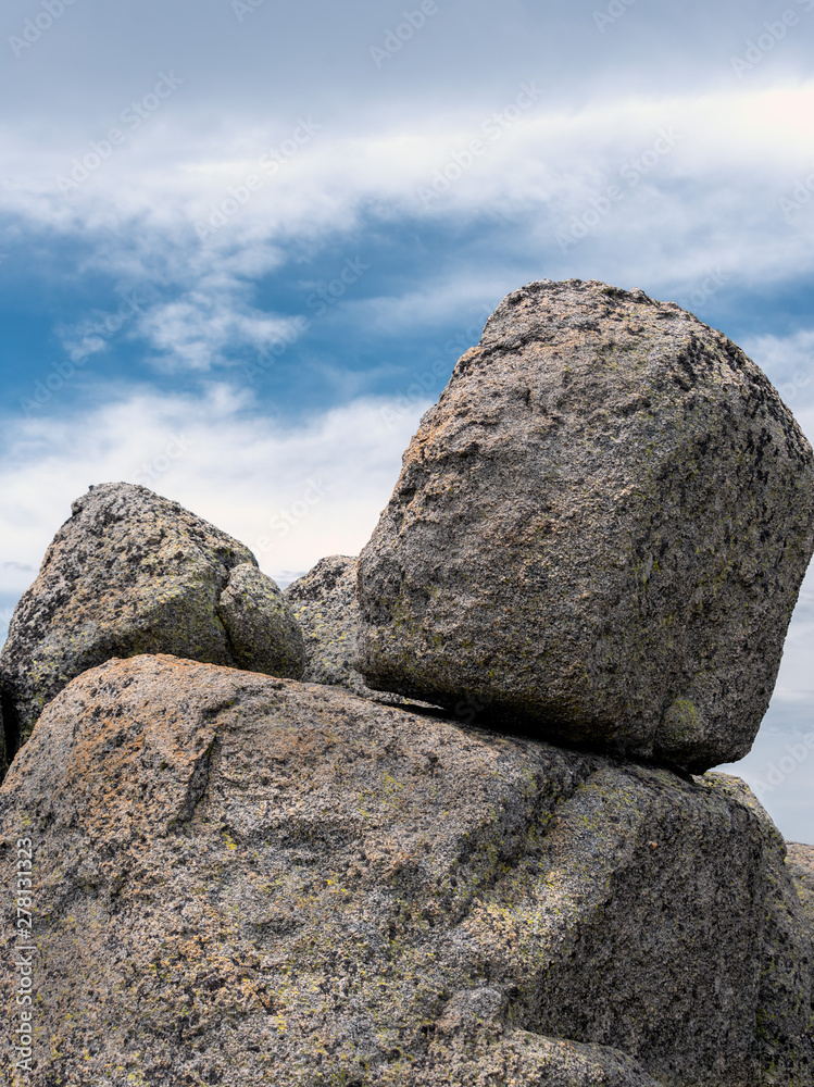 Located on the walk from Thredbo to Mount Kosciuszko Australia. Large granite rock boulders with a blue and white cloudy sky Located on the walk from Thredbo to Mount Kosciuszko Australia. Large granite rock boulders with a blue and white cloudy sky