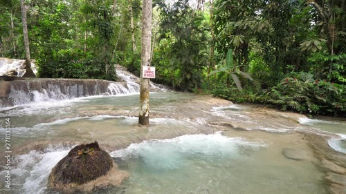 A beautiful panning view of the cascading waterfalls and rapids at Dunn's river falls with lush vegetation in Ocho Rios on the tropical island of Jamaica a popular travel destination. photo