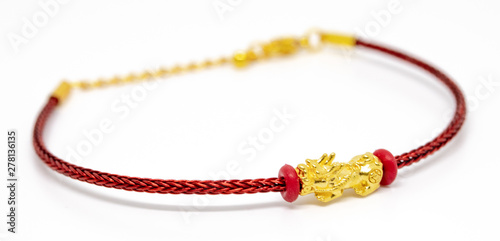 Red string bracelet with golden Dragon Pixiu or Pi Yao on white background. Traditional of china for Wealth and Good Fortune.