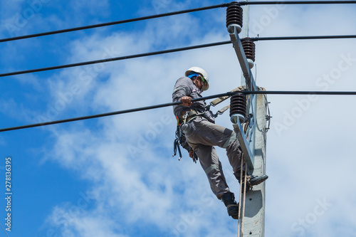 Electricians repairing,electricians repairing wire on electric power pole, power linesman climb the pole.It's a dangerous job.