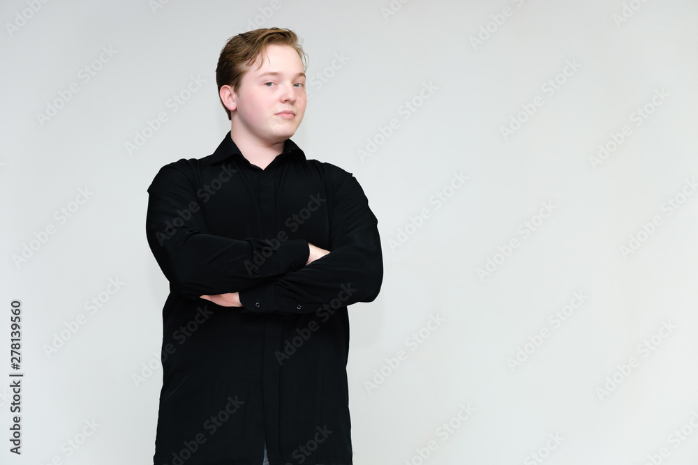 Portrait to the waist on a white background of a handsome young man in a black shirt. stands directly in front of the camera in different poses, talking, showing emotions, showing hands. Portrait to the waist on a white background of a handsome young man in a black shirt. stands directly in front of the camera in different poses, talking, showing emotions, showing hands.