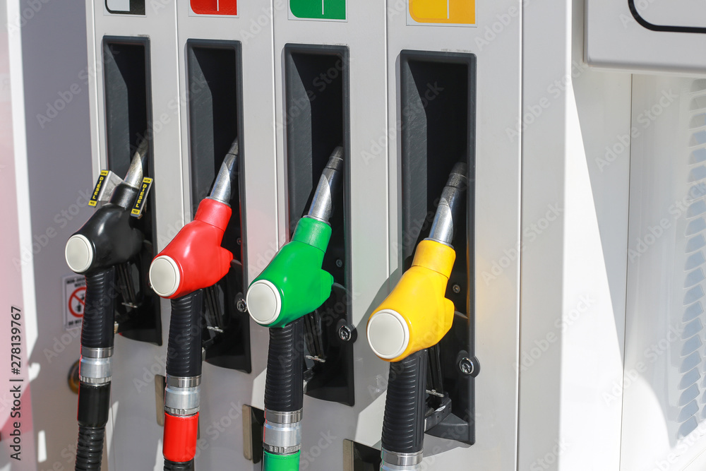 Gasoline station, gas pump nozzle, petrol station. Multi-colored handles four filling guns Gasoline station, gas pump nozzle, petrol station. Multi-colored handles four filling guns