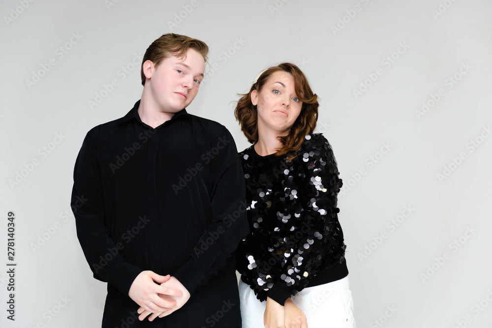 Portrait below the belt on a white background pretty young brunette woman in a black sweater and a young man in a black shirt. Standing in different poses, talking, showing emotions. Portrait below the belt on a white background pretty young brunette woman in a black sweater and a young man in a black shirt. Standing in different poses, talking, showing emotions.