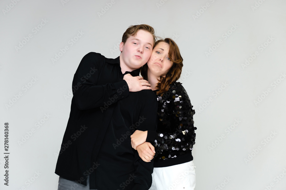 Portrait below the belt on a white background pretty young brunette woman in a black sweater and a young man in a black shirt. Standing in different poses, talking, showing emotions. Portrait below the belt on a white background pretty young brunette woman in a black sweater and a young man in a black shirt. Standing in different poses, talking, showing emotions.