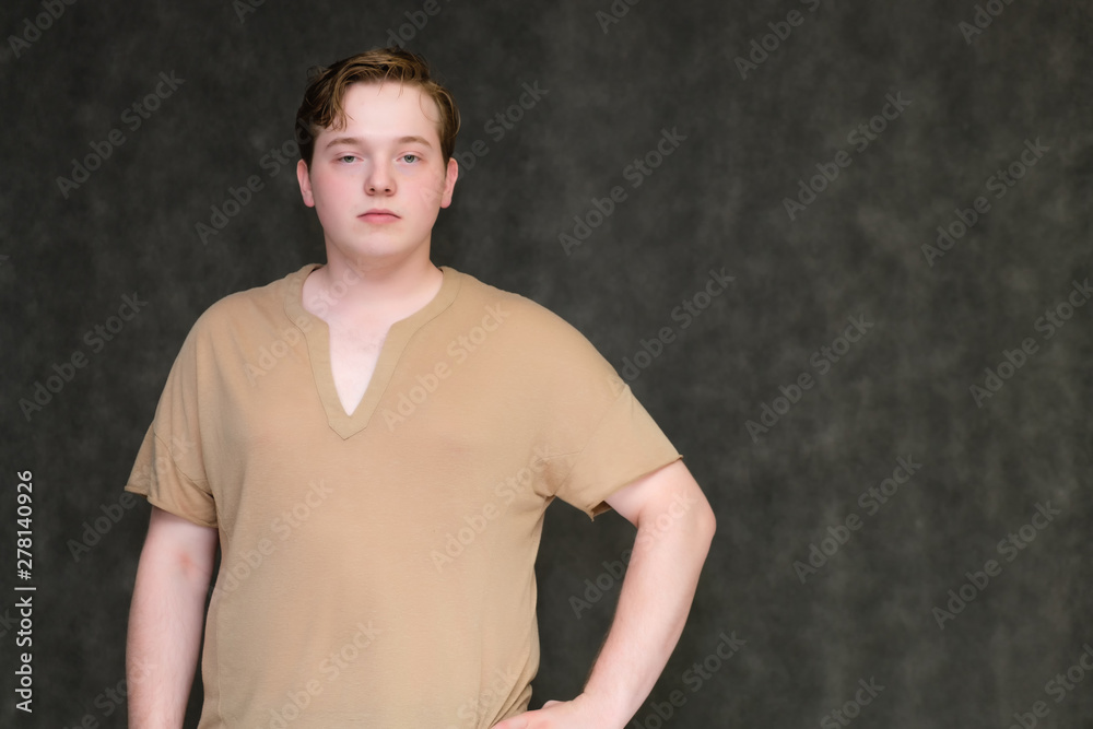 Portrait to the waist on a gray background of a handsome young man in a brown T-shirt. stands directly in front of the camera in various poses, talking, demonstrating emotions. Portrait to the waist on a gray background of a handsome young man in a brown T-shirt. stands directly in front of the camera in various poses, talking, demonstrating emotions.