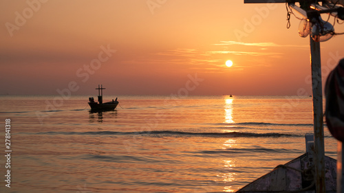 seascape with sunrise skyline and fisherman boat silhouette