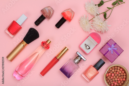 Gift boxes, women cosmetics and flowers on a pink background.