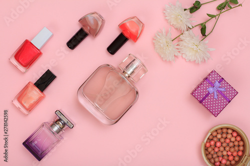 Gift box, flowers and women cosmetics on a pink background.