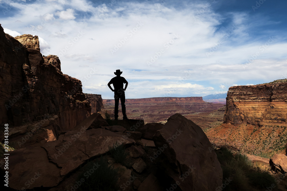 Hiker in cowboy hat at overlook - Silhouette on Shafer Trail - Canyonlands
