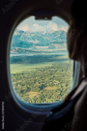 Women looking throw teh window in airplane, during landing in Montenegro.