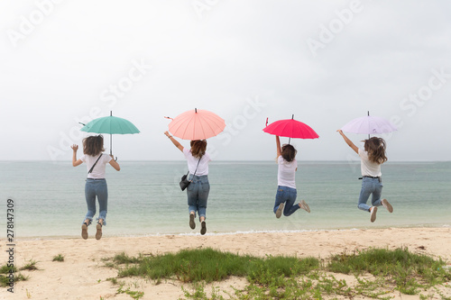 雨の中の若い4人の女性 沖縄のビーチ