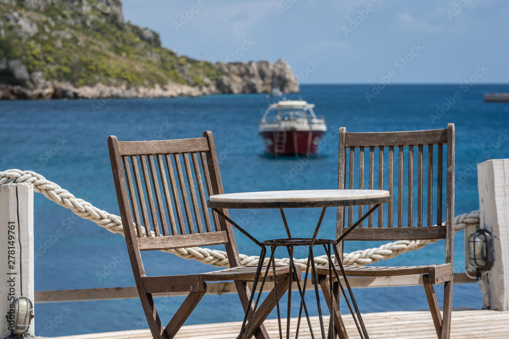 Wooden chairs and  table on a deck platform