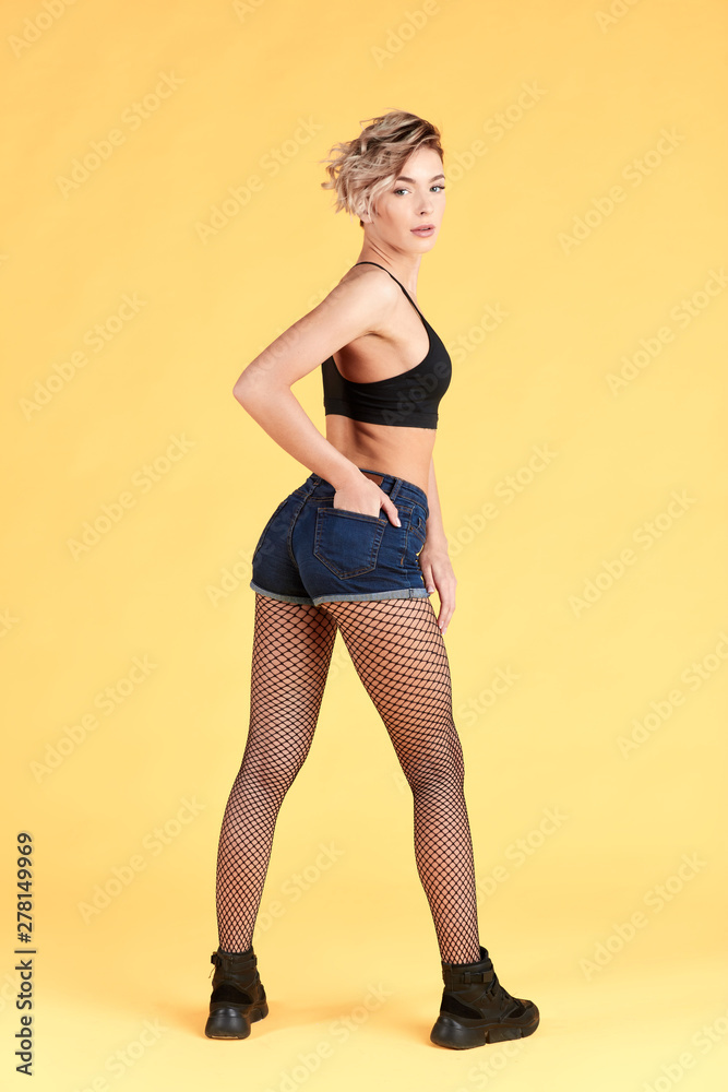 sexy gorgeous woman looking about. isolated yellow background, studio shot. full length photo.sport, fitness concept. body care sexy gorgeous woman looking about. isolated yellow background, studio shot. full length photo.sport, fitness concept. body care