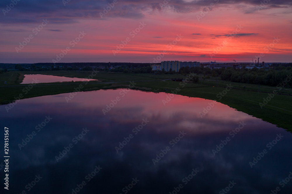 Smooth lakes in the fields of Belarus on a beautiful crimson sunset