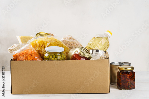 Various canned food, pasta and cereals in a cardboard box.