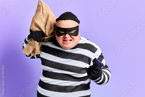 Foto angry frustrated robber shooting with a pistol, endanger the life