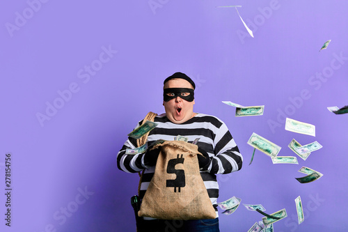 Foto plump thief is surprised at much money in the sack