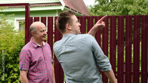 two farmers shaking hands and talking to each other on sunny day