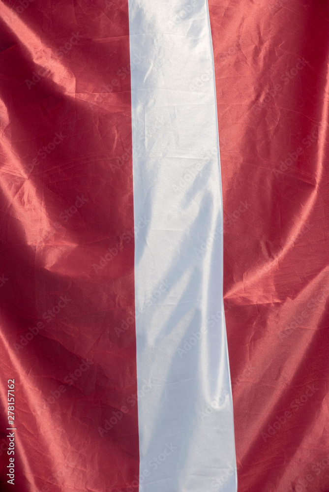 Hängende Flagge von Lettland an einem Masten
