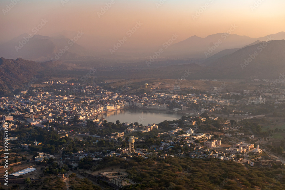 Morning in Pushkar, India, view from above. Dawn view of a lake in Indian city. hills in fog before sun rises. lake with mountains around. popular touristic town in Ajmer district of India