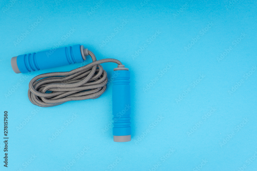 Skipping rope or jumping rope isolated on blue background. Selective focus and crop fragment Skipping rope or jumping rope isolated on blue background. Selective focus and crop fragment