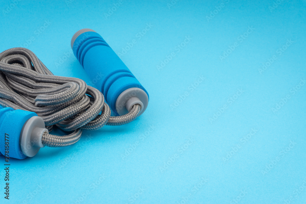 Skipping rope or jumping rope isolated on blue background. Selective focus and crop fragment Skipping rope or jumping rope isolated on blue background. Selective focus and crop fragment