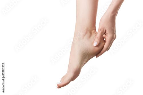 Female bare foot tired of tight footwear, woman touch her heel by fingers. Isolated on white, close up © junky_jess
