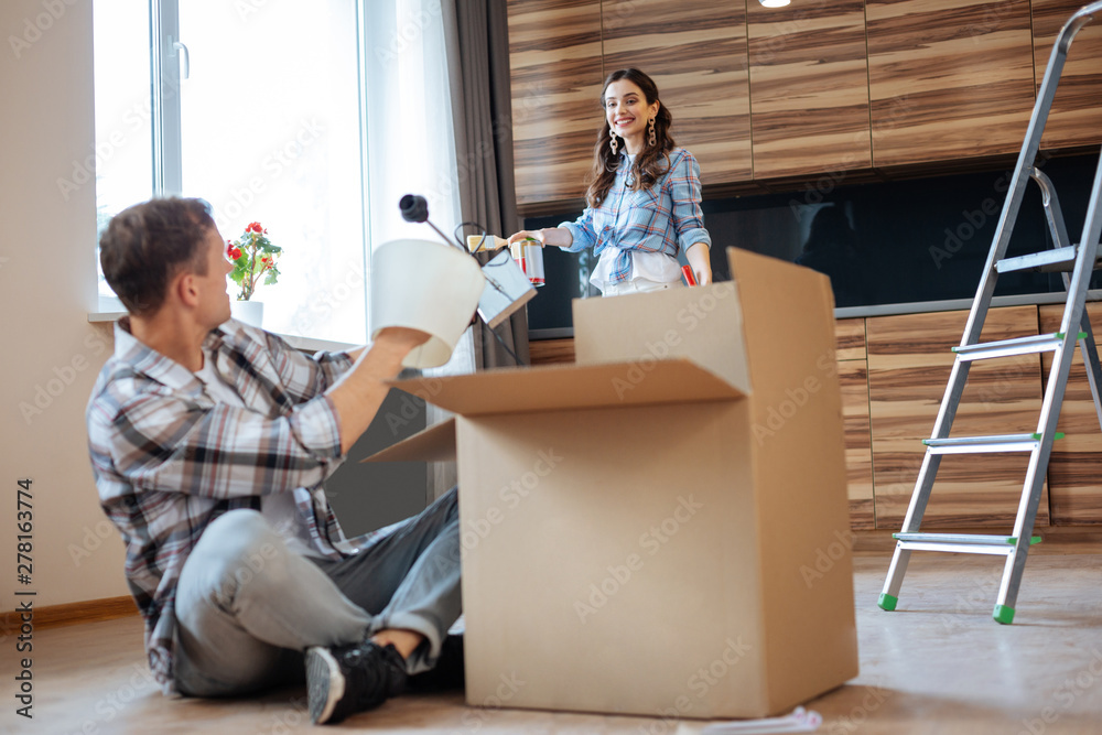 Husband and wife talking while unpacking things moving to house Husband and wife talking while unpacking things moving to house
