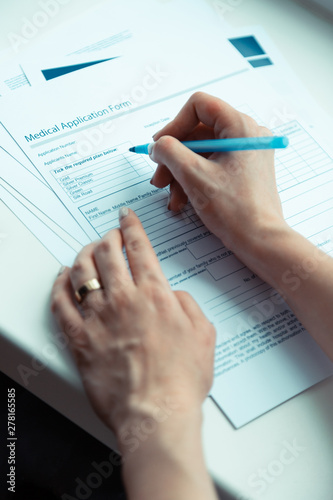 Woman holding pen and signing papers buying medical insurance