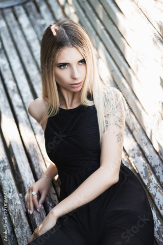Young blond woman with tattoo. Portrait of young cute girl. Close-up.