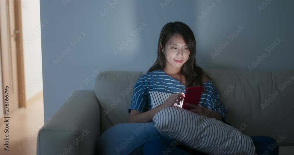 Woman use of cellphone at home in the evening