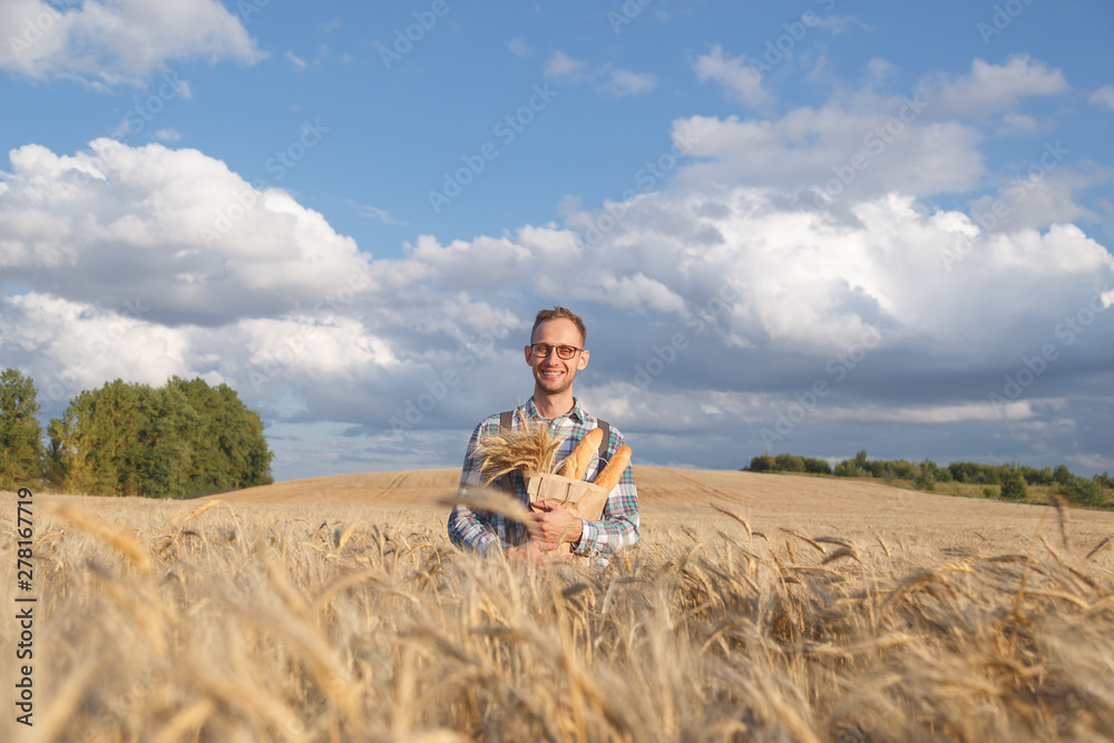 Male farmer or baker with baguettes in rye, wheat field Male farmer or baker with baguettes in rye, wheat field