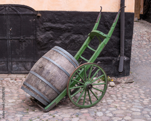 Trolley for transporting wooden barrels. Wooden barrel on a trolley. Old cart. Old barrel