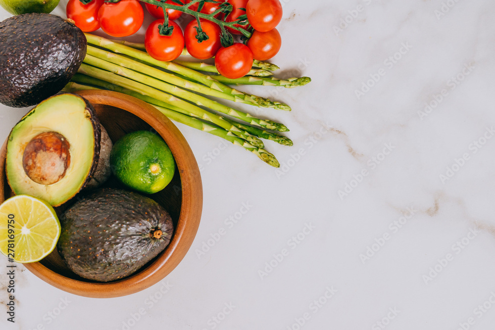 Fresh healthy vegetables in wooden plate on white marble background Fresh healthy vegetables in wooden plate on white marble background