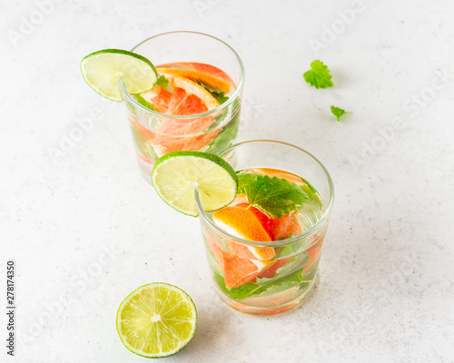 Glass of cool infused water with fresh grapefruit, lime and mint, (lemonade, cocktail). Detox drink, health care, fitness, diet concept.