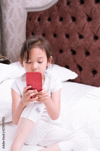 Chinese Girls Sitting in Bed and Watching Mobile Phones