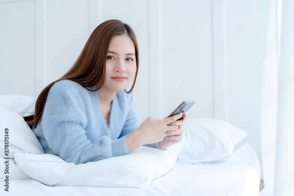 happiness beautiful asian woman smile morning wakeup on white bed soft pillow with hand hold smartphone bedroom background happiness beautiful asian woman smile morning wakeup on white bed soft pillow with hand hold smartphone bedroom background
