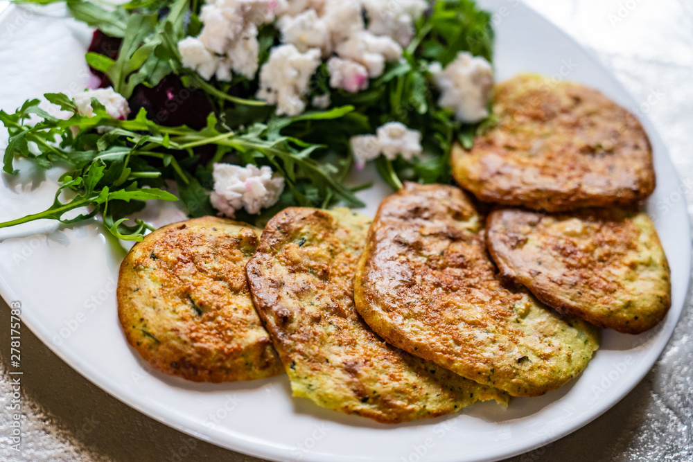 Pancakes with greek salad on white plate Pancakes with greek salad on white plate