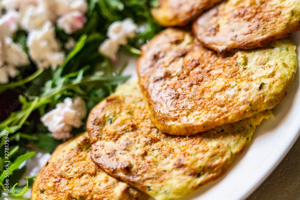 Pancakes with greek salad on white plate Pancakes with greek salad on white plate