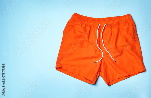 Stylish male swim trunks on color background, top view with space for text. Beach object photo
