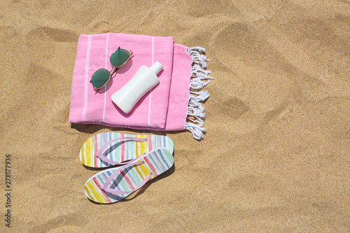 Set of different beach objects on sand, flat lay. Space for text