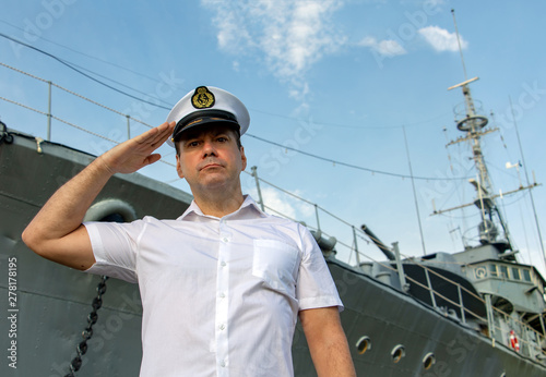 Navy officer standing beside warship and do salute Fototapeta