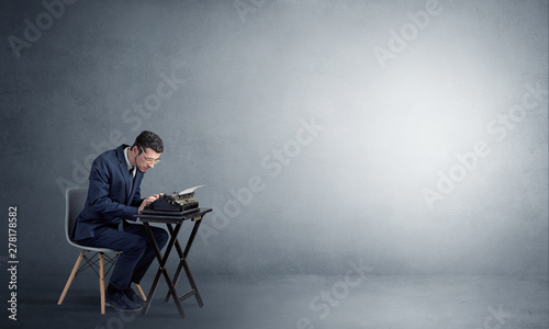 Man working hard on a typewriter in an empty space © ra2 studio