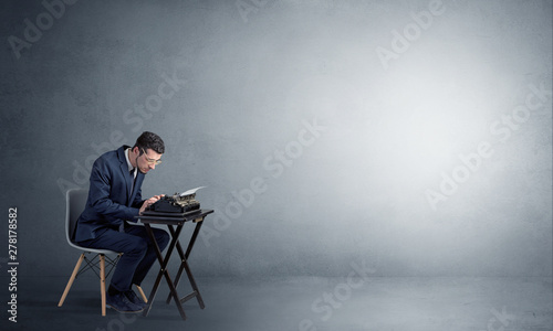 Man working hard on a typewriter in an empty space