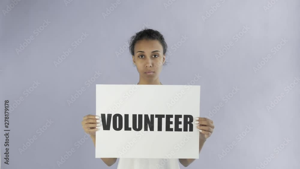 Afro-American Girl Activist With Volunteer Poster on grey background Afro-American Girl Activist With Volunteer Poster on grey background